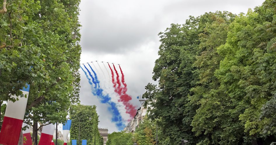 PARIS - JULY 14: People are watching French Patrouille de France at a military parade in the Republic Day (Bastille Day) on Champs Elysees in Paris, France on July 14, 2012.